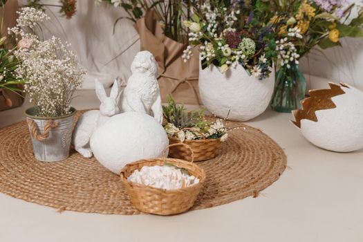 Interior floral Easter composition. Figurines of Easter bunnies and a large eggshell. The concept of home decoration for the Happy Easter holiday