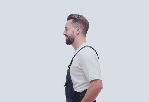 side view. smiling man in overalls looking forward to copy space. isolated on white background