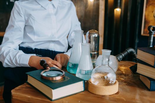 Schoolgirl perform chemical experiments. Flasks with solutions and chemical formulas on the blackboard in the school classroom. Back to school. School and preschool education.