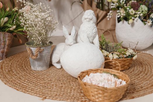 Interior floral Easter composition. Figurines of Easter bunnies and a large eggshell. The concept of home decoration for the Happy Easter holiday