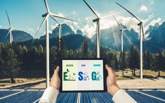 Green business transformation for environment saving and ESG business concept. Businessman using tablet to set corporate goal toward environmental friendly management and alternative clean energy use.