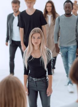 image of a serious woman standing in front of a casual group of young people.