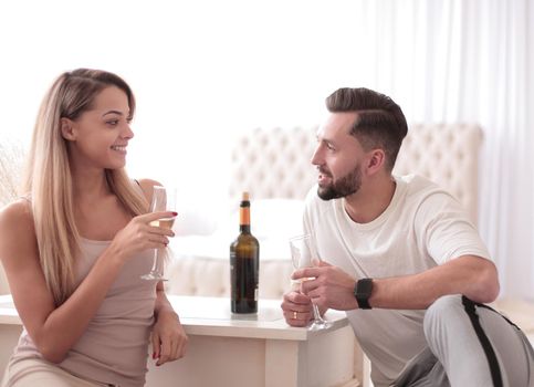 close up. couple in love with glasses of wine talking sitting in the kitchen