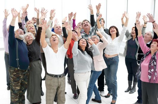 a group of elderly people are reaching up