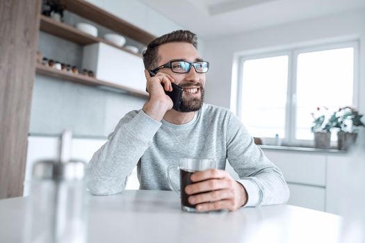 close up. attractive man talking on his smartphone during Breakfast