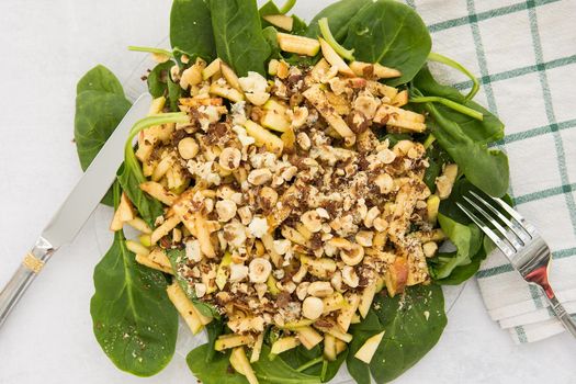 Vegan salad with spinach, nuts and Apple. Cooking at home, home-cooked food. We cook in quarantine.