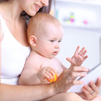 happy mom and baby are looking at the digital tablet screen.people and technology