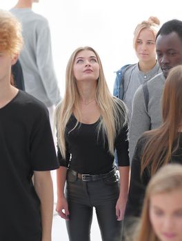 image of a serious woman standing in front of a casual group of young people.