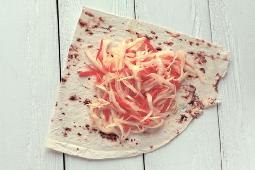 cabbage salad and pita bread on the wooden table.