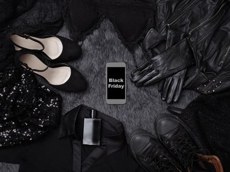Black Friday Sale Fashion Dark Background. Black Clothes Flat Lay with Shoes, Fragrance, Lingerie, Dress, Gloves and Phone in center. Offer Shop Concept