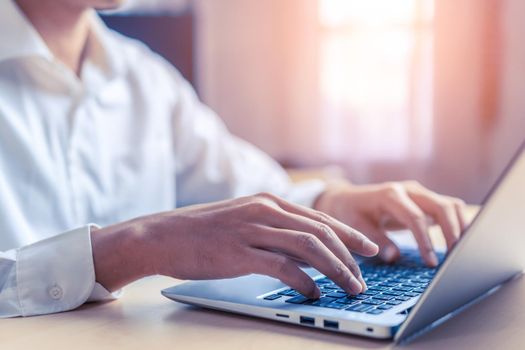 Businessman hand typing on computer keyboard of a laptop computer in office. Business and finance concept.