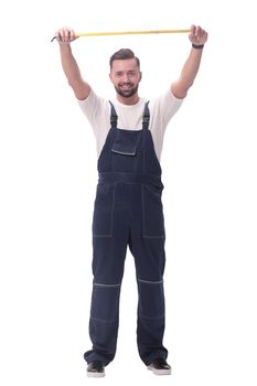 in full growth. smiling man showing construction - roulette. isolated on white background