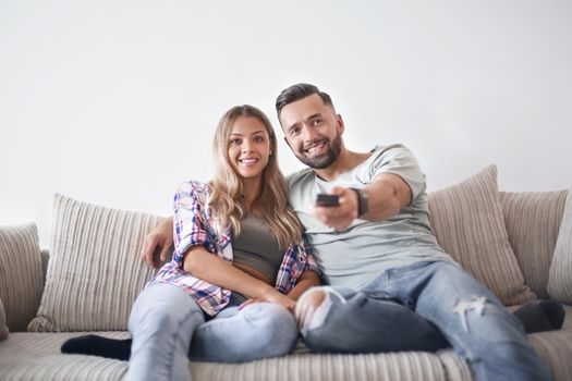 Young couple enjoying themselves on the sofa in the living room. photo with copy space