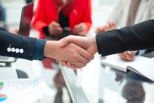 Businessmen making handshake in an office.