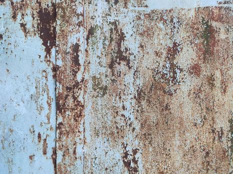 Corroded metal background. Rusted white painted metal wall. Rusty metal background with streaks of rust. Rust stains. The metal surface rusted spots. Rystycorrosion.