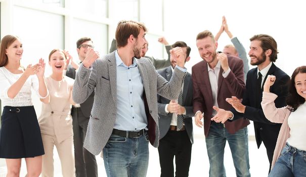 happy young businessman standing in front of his business team. success concept