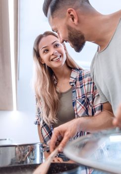 close up. young husband and wife looking into a pot of soup . photo with copy space