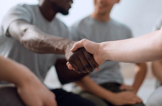 close up. smiling guy shaking hands with his friend. photo with space for text