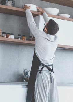 smiling man choosing spices in the kitchen. photo with copy space