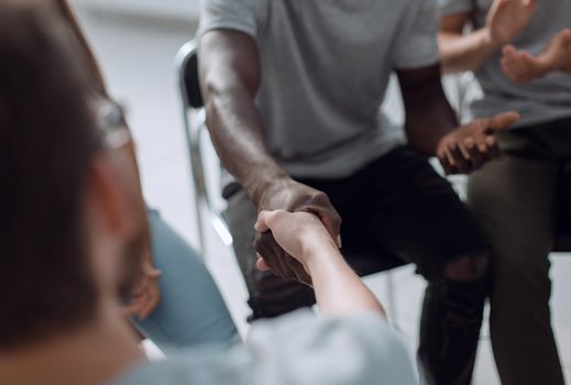 close up. smiling guy shaking hands with his friend. photo with space for text