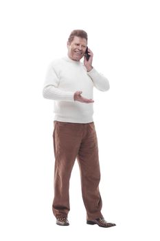 full- length . smiling casual man talking on his smartphone . isolated on a white background