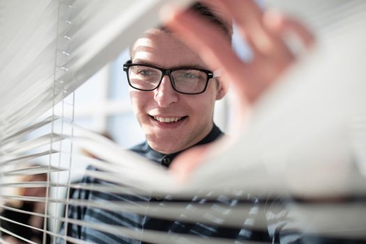 Happy businessman in office looking out the window