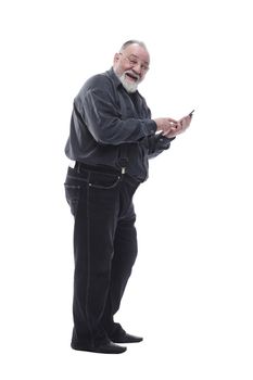side view. smiling elderly man typing on his smartphone isolated on a white background.