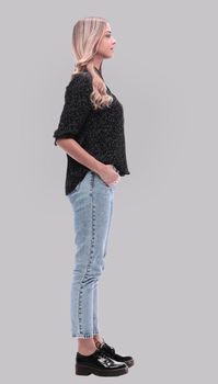 side view. modern young woman in jeans and black blouse. isolated on white background