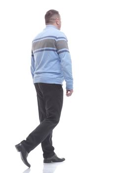 side view. a serious man in a sweater walks forward. isolated on a white background