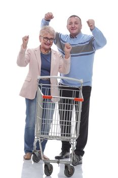 in full growth. cute couple with shopping cart. isolated on a white background