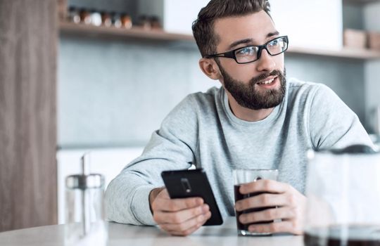 close up. attractive man reading e-mails during Breakfast