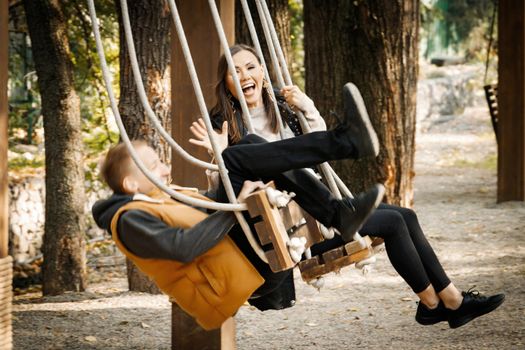 A young man on a date in the park rolled over on a swing. A fun date. High quality photo