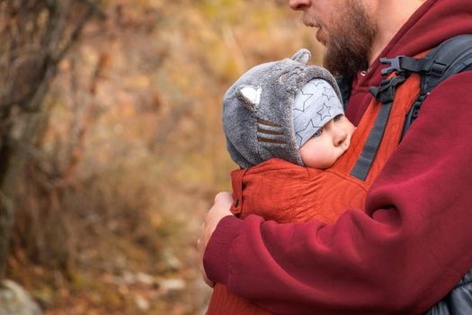 Babywearing father autumn outdoor with copy space.