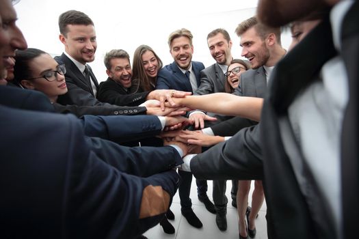 concept of team building. large group of business people standing with folded hands together