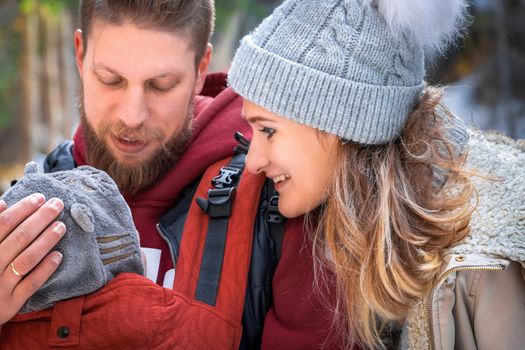 Babywearing winter walk of young parents with their children outdoor.