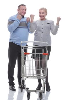 in full growth. casual couple with shopping cart . isolated on a white background