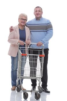 in full growth. cute couple with shopping cart. isolated on a white background