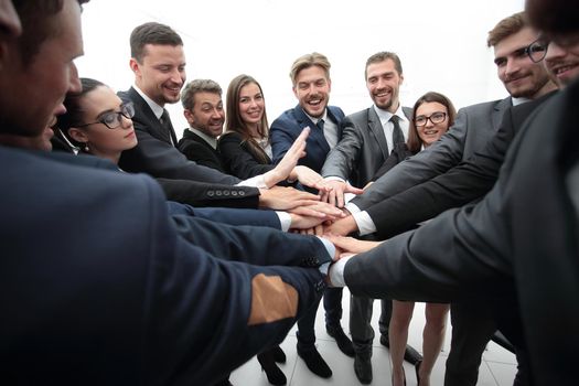 concept of team building. large group of business people standing with folded hands together