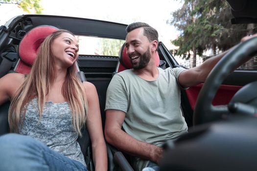 close up.beautiful couple sitting in the front seat of a convertible.travel together