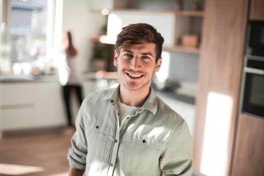 handsome young man standing in his kitchen. photo with copy space