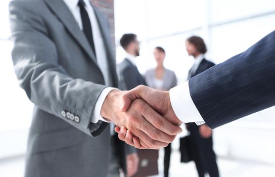 closeup.reliable handshake of business partners on the background of business team