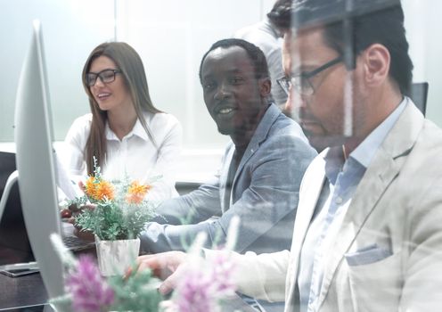 behind the glass.the business team works intently at the Desk