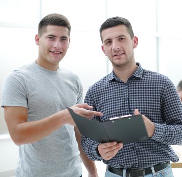 two young employees discussing a business document . office workdays