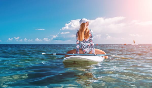 SUP Stand up paddle board. Young woman sailing on beautiful calm sea with crystal clear water. The concept of an summer holidays vacation travel, relax, active and healthy life in harmony with nature