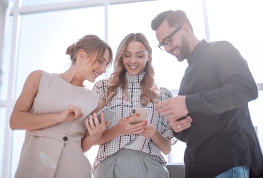 close up.business team looking at the screens of their smartphones.