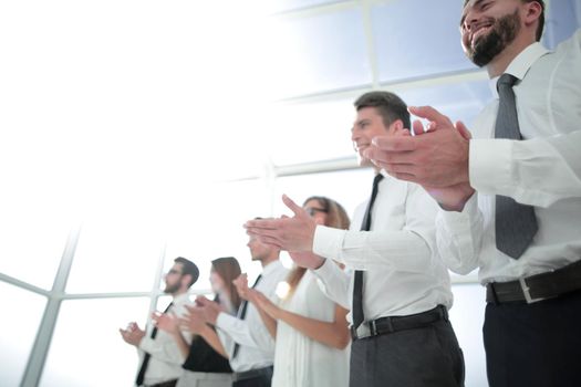 business background.applauding business team standing in the office . photo with copy space