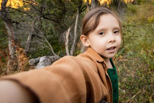 Girl 5 years old takes a selfie in a hike in nature.