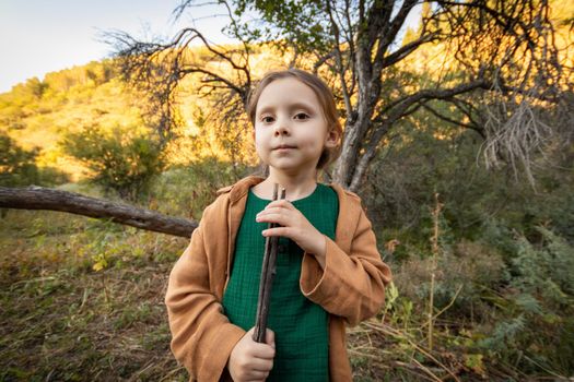 Little cute girl 5 years old in comfortable rustic muslin clothes in nature.