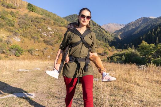 Slingomama enjoys babywearing a sling for her child on a long hike.