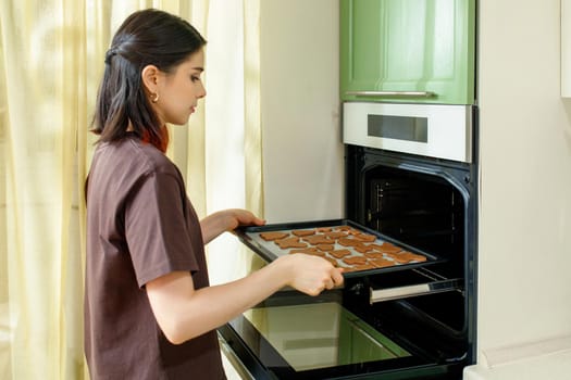 Baking homemade cookies in a modern built-in oven in a home kitchen.